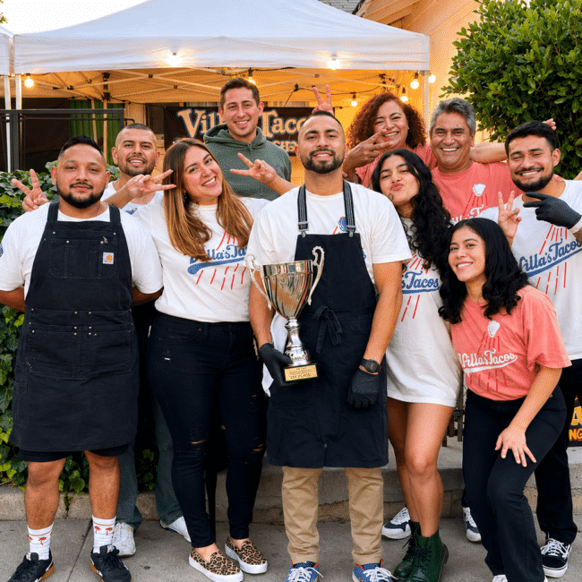 Villa's Tacos team holding the L.A. Taco Madness championship trophy outside their Highland Park Los Angeles location